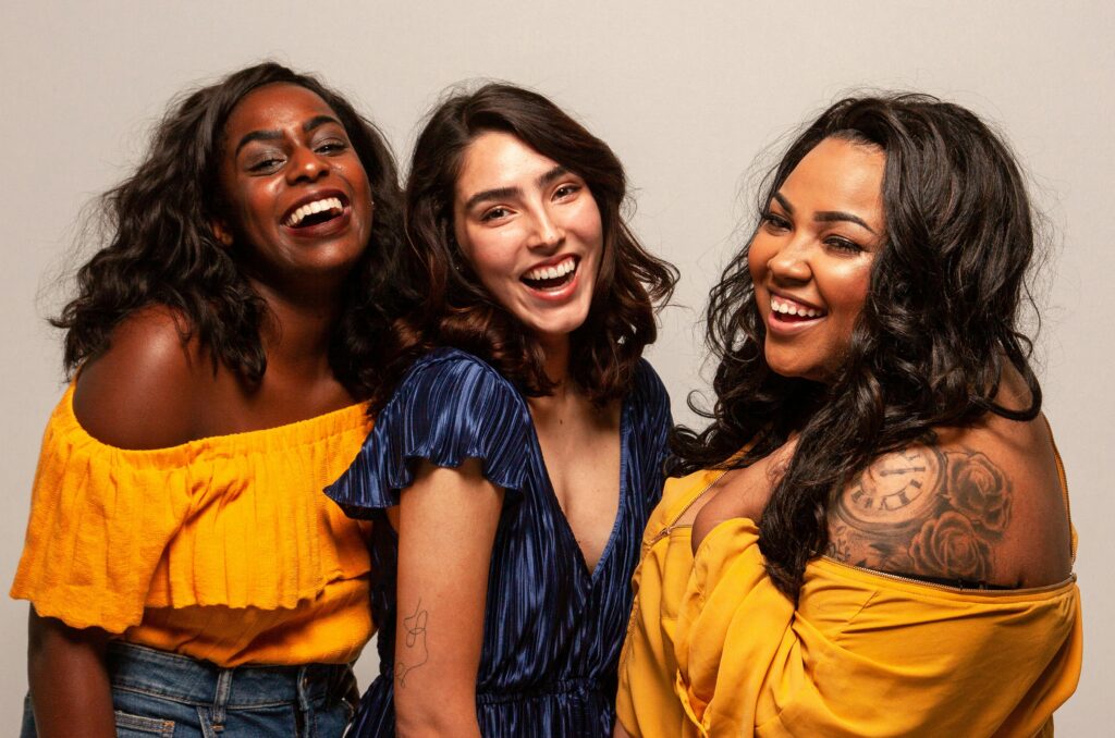 pexels-photo-1644888-1644888 Joyful group of diverse women laughing together in bright outfits.